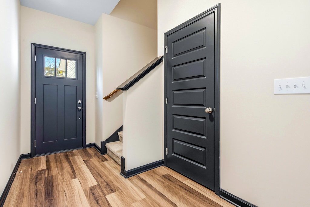 Dexter-15 The Birch floor plan entry foyer by Maplewood Homes featuring modern front door, staircase, and luxury vinyl plank flooring