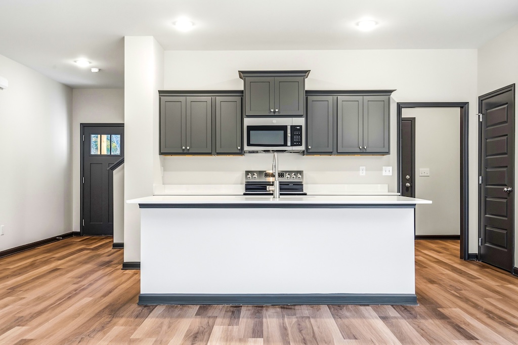 Dexter-19 The Birch floor plan kitchen by Maplewood Homes featuring gray cabinets, large island, and open layout