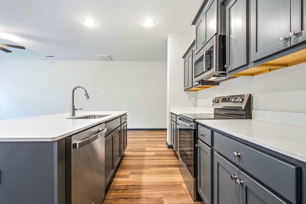 Dexter-22 The Birch floor plan kitchen by Maplewood Homes featuring white countertops, stainless appliances, and open layout