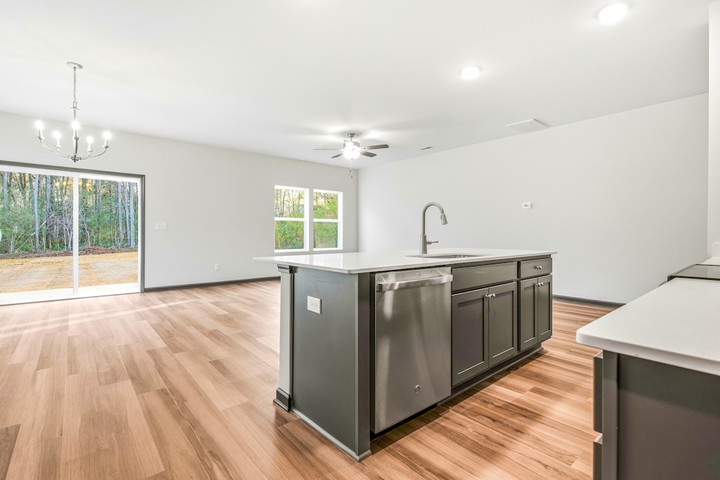 Dexter-23 The Birch floor plan open kitchen and living room by Maplewood Homes with large island and natural light