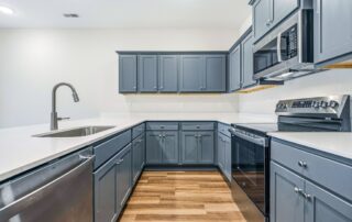Tercel-9 Aspen floor plan kitchen by Maplewood Homes featuring ample counter space, gray cabinets, and modern finishes